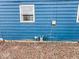 Exterior of the blue home highlighting the gas meter and a small window at 2370 N Moreland Ave, Indianapolis, IN 46222