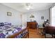 Comfortable bedroom features a ceiling fan, hardwood floors, and desk with chair at 3079 Limber Pine Dr, Whiteland, IN 46184