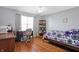 Bright bedroom with hardwood floors, ceiling fan, and desk area at 3079 Limber Pine Dr, Whiteland, IN 46184