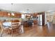 Spacious kitchen featuring wood cabinets, hardwood floors, stainless steel appliances, a center island, and a dining table at 3079 Limber Pine Dr, Whiteland, IN 46184