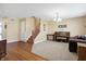 Welcoming living room with neutral walls, plush carpet, hardwood entry, and a view of the staircase at 3079 Limber Pine Dr, Whiteland, IN 46184
