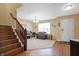 Inviting living room showcasing a staircase, neutral walls, plush carpet, hardwood entry, and a comfortable sitting area at 3079 Limber Pine Dr, Whiteland, IN 46184