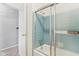 Bright bathroom showcasing a bathtub with blue tile surround and a glass door at 3125 Anniston Dr, Indianapolis, IN 46227