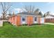Side view of the red brick ranch home showcasing its well maintained lawn and classic design at 3125 Anniston Dr, Indianapolis, IN 46227