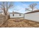 Backyard view with brick firepit, detached garage, and wood fence at 317 Albany St, Indianapolis, IN 46225