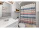 Charming bathroom with gray cabinets, beadboard walls, and colorful striped shower curtain at 317 Albany St, Indianapolis, IN 46225