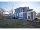 View of the backyard and the side of the blue house with a red door at 3406 E 20Th St, Indianapolis, IN 46218