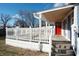 Inviting front porch with white railing and a vibrant red door at 3406 E 20Th St, Indianapolis, IN 46218