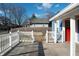 Exterior deck with white railing leads to a charming home with a red door at 3406 E 20Th St, Indianapolis, IN 46218