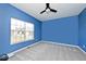 A blue bedroom featuring carpet, large window, and ceiling fan at 3532 Danbury Ct, Bargersville, IN 46106
