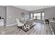 Open-concept dining area featuring gray wood floors and neutral decor with many windows at 3532 Danbury Ct, Bargersville, IN 46106
