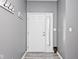 Bright entryway with white door and decorative hooks with stylish luxury vinyl plank flooring at 3532 Danbury Ct, Bargersville, IN 46106