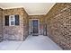 Covered porch entrance featuring brick walls, black door, and a 'Welcome' sign at 3532 Danbury Ct, Bargersville, IN 46106