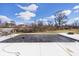 Backyard pool with cover surrounded by a white patio and trees at 3532 Danbury Ct, Bargersville, IN 46106