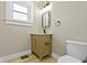Bathroom featuring a wooden vanity cabinet, elegant light fixture, and classic black accessories at 360 S Spencer Ave, Indianapolis, IN 46219