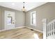 Inviting entryway featuring new flooring, a stylish light fixture, and a door with glass insert for natural light at 360 S Spencer Ave, Indianapolis, IN 46219