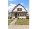 Inviting two-story home boasts a classic design, complemented by a lush green lawn and beautiful landscaping at 360 S Spencer Ave, Indianapolis, IN 46219