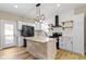 Bright kitchen featuring a stone-clad island, stainless steel appliances, and modern lighting at 360 S Spencer Ave, Indianapolis, IN 46219