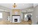 Open living room with stylish light fixtures, a cozy fireplace, and a seamless flow into the adjacent kitchen area at 360 S Spencer Ave, Indianapolis, IN 46219