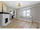 Bright living room features a window seat, stylish light fixtures, a cozy fireplace, and an open view into the kitchen at 360 S Spencer Ave, Indianapolis, IN 46219
