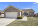Charming brick home featuring an attached two-car garage, manicured lawn, and inviting entryway at 3677 Cedar Cove Ct, New Palestine, IN 46163