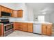 Well-lit kitchen with stainless steel appliances and wood cabinets and breakfast bar at 3677 Cedar Cove Ct, New Palestine, IN 46163