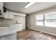 Bright kitchen with white cabinets, modern laminate flooring, and ample natural light from two large windows at 3732 Wellington Ave, Indianapolis, IN 46226