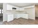 Bright kitchen featuring white cabinets, laminate flooring, and modern appliances at 3732 Wellington Ave, Indianapolis, IN 46226