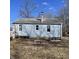 View of the back of the home, showing the light blue siding and a chimney on the roof at 3748 N Olney St, Indianapolis, IN 46218