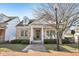 Charming brick and siding home featuring a covered porch and landscaped front yard at 4215 Heyward Pl, Indianapolis, IN 46250