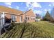 Backyard view with brick house, patio and open green space at 5115 Baltustrol Dr, Avon, IN 46123