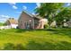 Brick home exterior view, surrounded by lush lawn, mature trees, and manicured landscaping at 5115 Baltustrol Dr, Avon, IN 46123