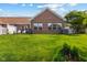 Brick home exterior view, surrounded by lush lawn, mature trees, and manicured landscaping at 5115 Baltustrol Dr, Avon, IN 46123