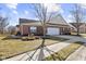 Charming brick home featuring a two-car garage and manicured front yard with green shutters and a welcoming appeal at 5115 Baltustrol Dr, Avon, IN 46123