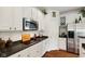 Bright kitchen with granite counters, stainless steel microwave, white cabinets, and hardwood floors at 5115 Baltustrol Dr, Avon, IN 46123