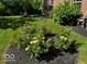 Professionally landscaped yard with colorful roses, iris, and fresh mulch at 5115 Baltustrol Dr, Avon, IN 46123