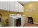 Laundry room features a washer and dryer, storage cabinets and yellow walls at 5115 Baltustrol Dr, Avon, IN 46123