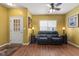 Cozy living room with a leather sofa, natural light, ceiling fan, and warm yellow walls creating a welcoming space at 5115 Baltustrol Dr, Avon, IN 46123