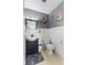 Well-lit bathroom with classic white tile and dark gray accents, vanity with a decorative mirror at 5195 N Frontage Rd, Fairland, IN 46126