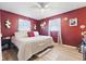 Red primary bedroom with hardwood flooring, two windows for natural light, and white furniture at 5195 N Frontage Rd, Fairland, IN 46126