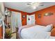 Bedroom with orange walls features wood-look flooring, bright natural light, and ceiling fan at 5195 N Frontage Rd, Fairland, IN 46126
