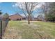 Green backyard with brick home, partial fence, and mature trees at 520 Denny Dr, Mooresville, IN 46158