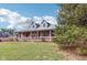 Traditional brick home showcasing a covered front porch and well-maintained lawn and mature landscaping at 520 Denny Dr, Mooresville, IN 46158