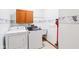 Bright laundry room with washer, dryer, utility sink, and storage cabinet at 520 Denny Dr, Mooresville, IN 46158