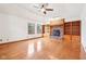 Bright living room featuring a brick fireplace, built-in shelves, ceiling fan, and hardwood floors at 520 Denny Dr, Mooresville, IN 46158
