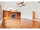 Living room featuring a brick fireplace, built-in shelves, ceiling fan, and hardwood floors at 520 Denny Dr, Mooresville, IN 46158