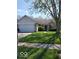 Charming single-story home with a well-maintained lawn, attached garage, and inviting entryway at 5851 Brobeck Ln, Indianapolis, IN 46254