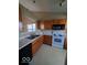 Practical kitchen with black dishwasher, white oven, wood cabinets and double sink at 5851 Brobeck Ln, Indianapolis, IN 46254