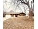 Exterior view of a one-story home with a garage, complemented by a lush front lawn and mature trees at 6116 Wixshire Dr, Indianapolis, IN 46254