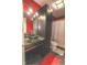 Red bathroom features a glass bowl sink and a decorative tile backsplash at 632 Middleham Cir, Beech Grove, IN 46107